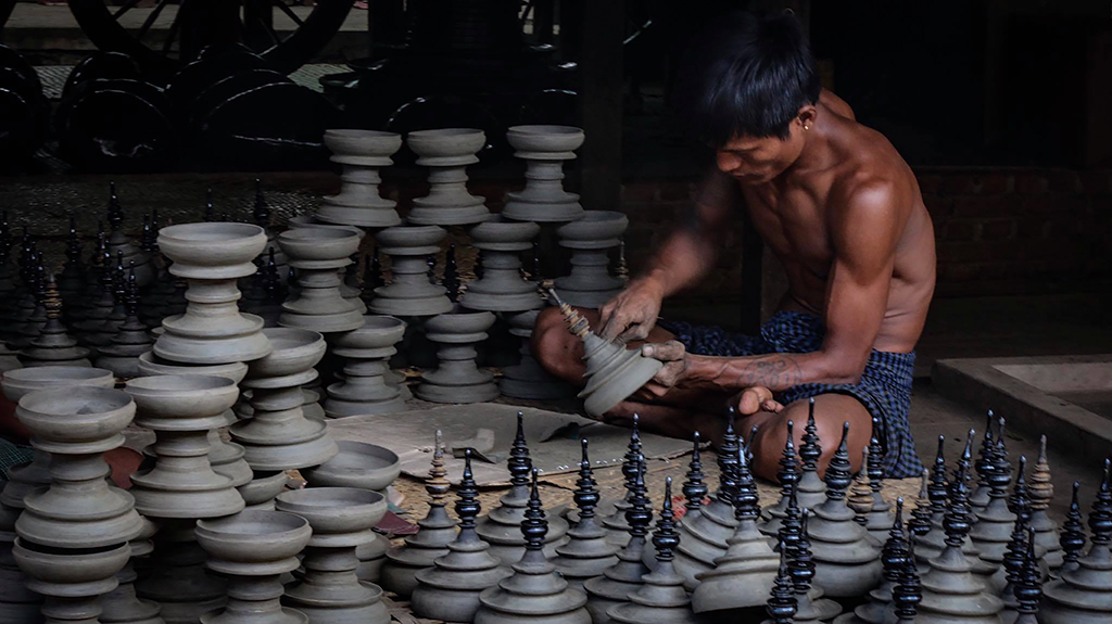 Sculpting the base with thayo paste during lacquer production.